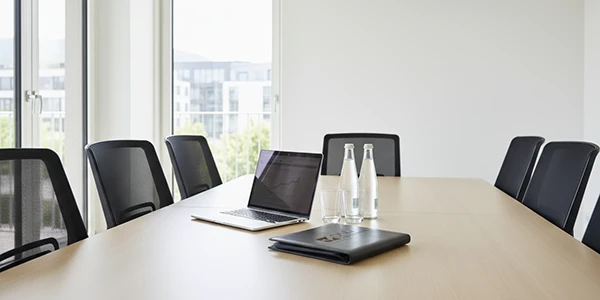 Ein moderner Konferenzraum für effektive Steuerberatung mit Laptop und Unterlagen für Treuhand-Dienstleistungen.