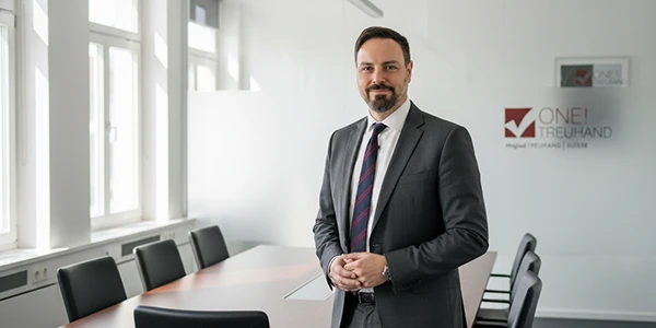 Ein Fachmann steht im Konferenzraum einer Treuhandfirma, bereit für kompetente Steuerberatung.