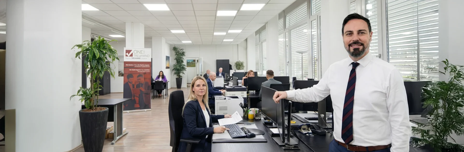 Moderner Büroraum einer Treuhand- und Steuerberatung mit freundlichem Team, effiziente Arbeitsumgebung, professionelle Beratung.