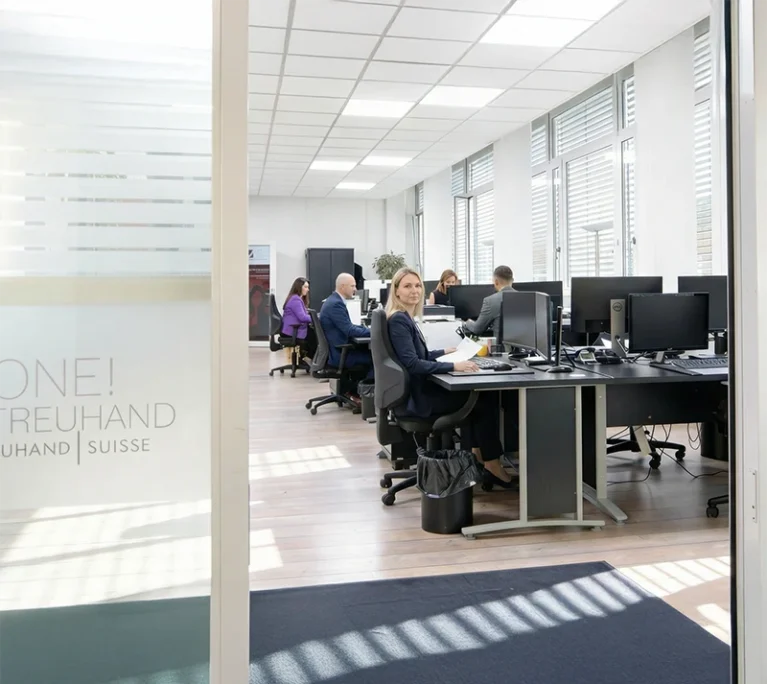 Das Team von One! Treuhand im Büro am arbeiten